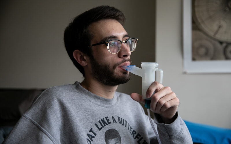 Cambridge, MA -- 01/24/19 -- Harvard Law School student Josh Hillman uses a medical air nebulizer to breathe in antibiotic mist to treat his cystic fibrosis. He first mixes together a liquid antibiotic and sterile water to fill the nebulizer, then breathes in the mist, which he must do on a daily basis. (Kayana Szymczak for STAT)